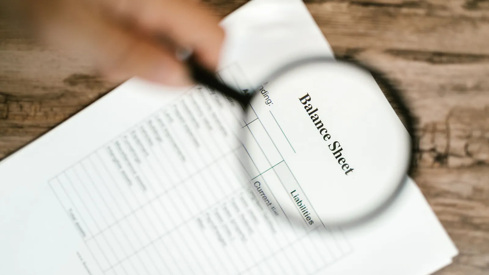 Magnifying glass over a report, reviewing content quality during core update recovery
