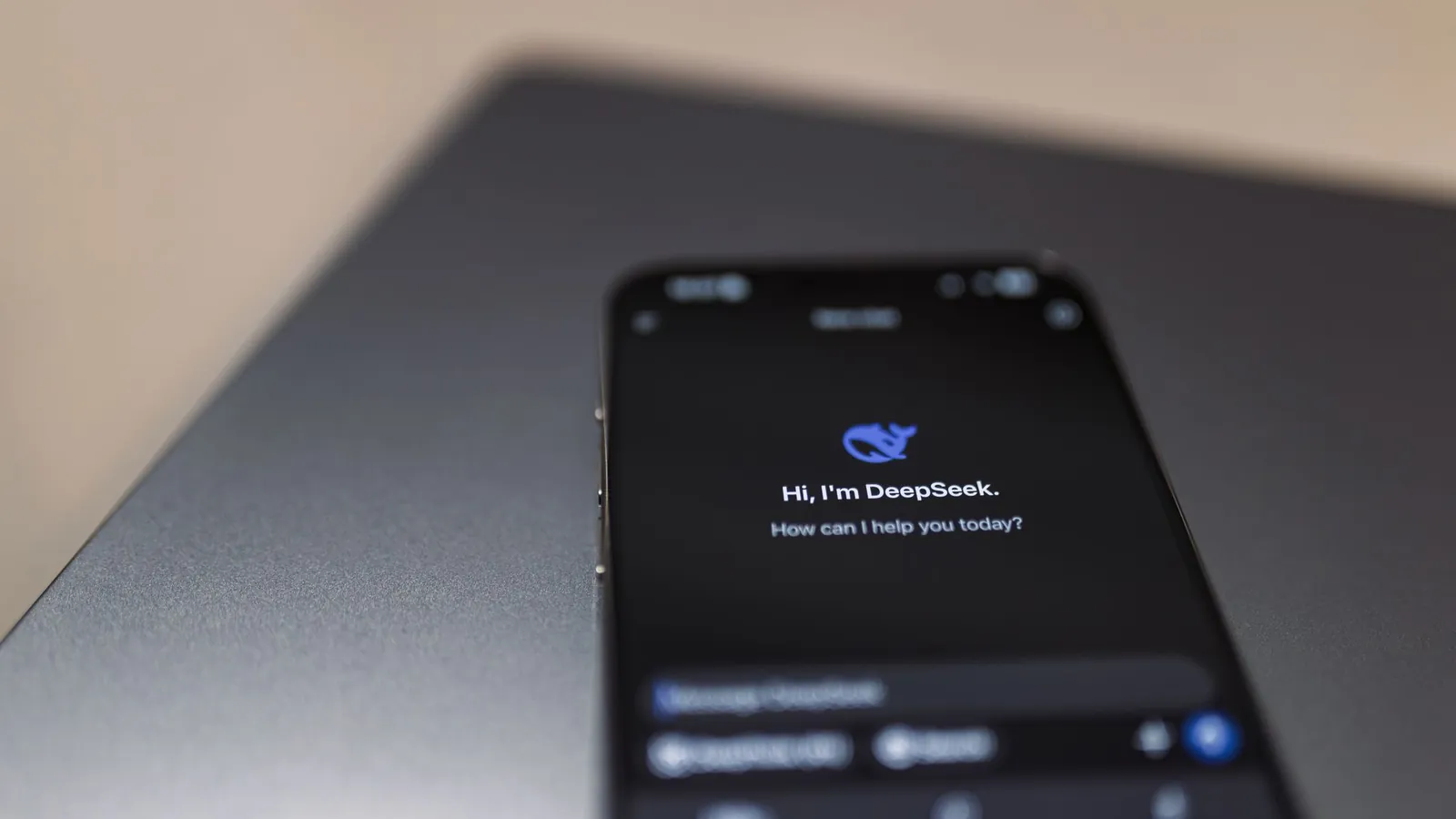 Smartphone showing an AI assistant over a laptop, where generative engine optimization decides which brands get mentioned