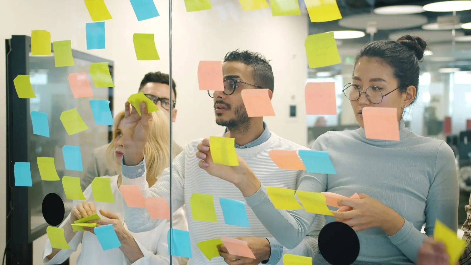 Team planning a digital marketing strategy with sticky notes on a glass wall